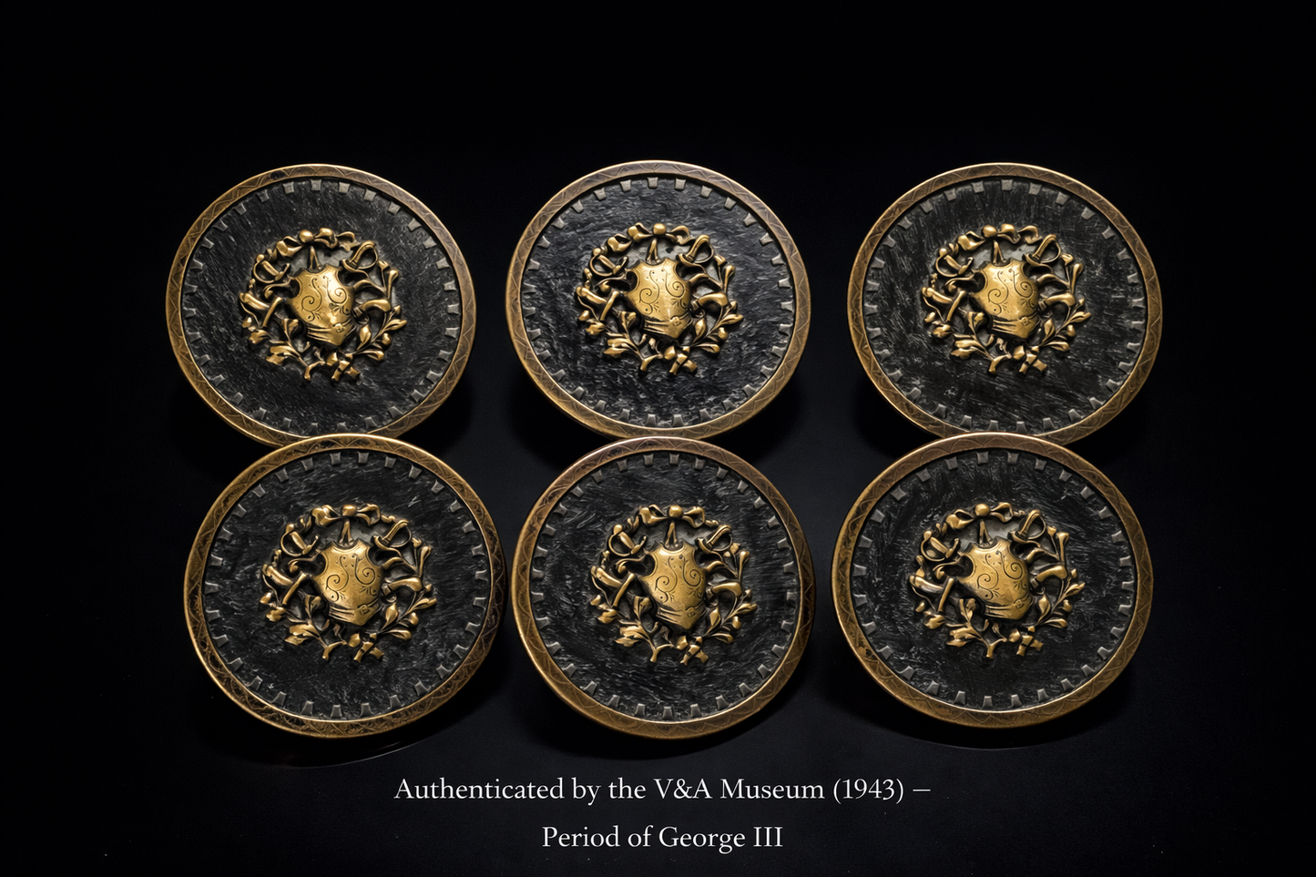 Six decorative metal buttons with a central emblem, authenticated by V&A Museum, on a black background.